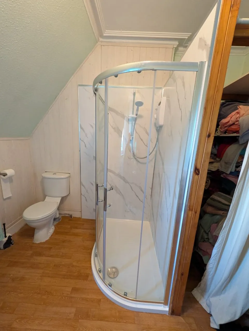 Curved shower enclosure with marble-effect wall panels
